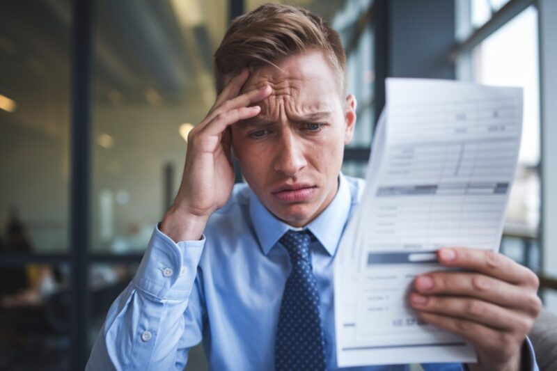 Un salarié préoccupé examine sa fiche de paie.