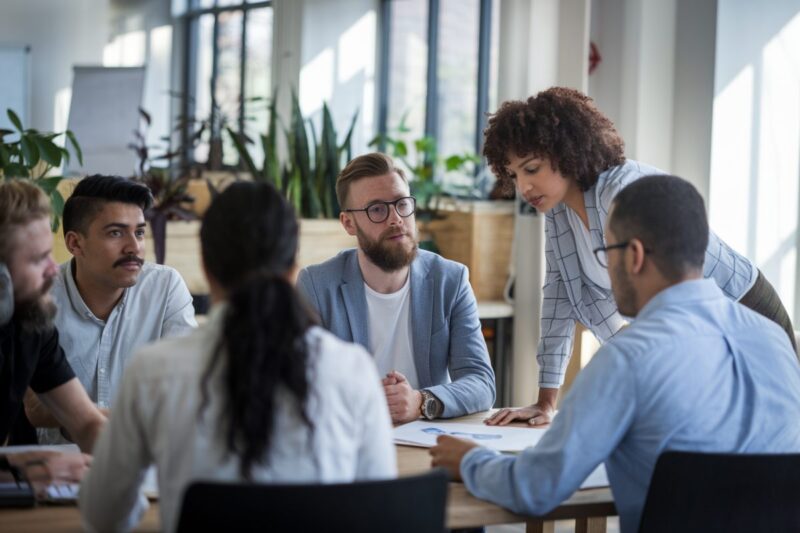 Des employés diversifiés en réunion collaborative dans un bureau moderne, illustrant le management empathique.